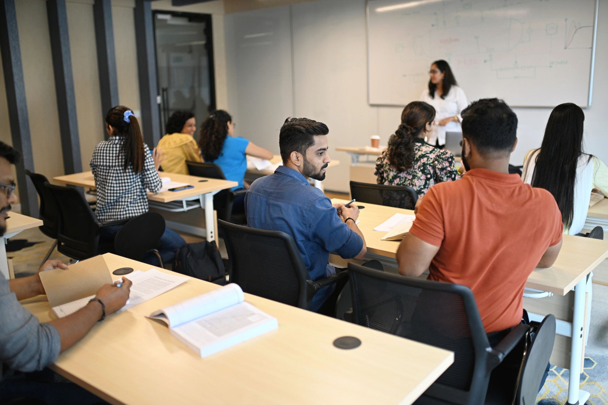 Mentor guiding students in a classroom environment